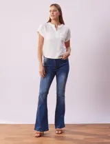 Remera blanca de tejido ribs con cuello a la base y escote en V. Tiene dos bolsillos aplicados en el frente y mangas cortas con dobladillo.