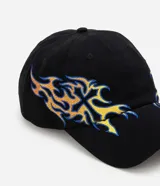 Gorra de algodón negra con visera curva y diseño estructurado, que presenta un bordado lateral con detalles tribales de fuego en tonos azules y dorados.
