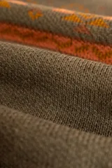 Sweater de lana color verde oliva con cuello redondo y diseño geométrico en tonos naranja.