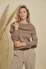 Buzo de tejido de punto color marrón, con cuello amplio y versátil que permite usarlo sobre los hombros o como cuello tipo buche. Es de manga larga y tiene un calce cómodo.