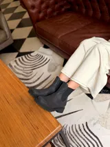 Bota tipo chelsea de cuero negro, con paneles elásticos laterales y suela track dentada.