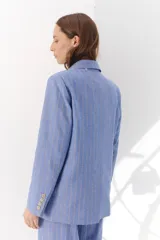 Blazer de lino color crudo con rayas verticales finas en color dorado, de corte recto, con solapas y cierre con un botón.