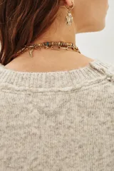 Sweater amarillo de calce relajado, mangas largas, cuello redondo y hombros caídos.