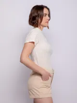 Short de tiro alto a rayas verticales en tonos beige y blanco, con cuatro bolsillos, cierre y botón metálico.