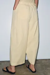 Pantalón de tiro medio confeccionado en mezcla de lyocell, con diseño de pierna ancha y tejido en espiga. Cuenta con cintura elástica ajustable con cordones y bolsillos laterales.