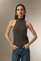Top tejido de punto color gris oscuro con cuello alto tipo polera y diseño sin mangas con corte halter.