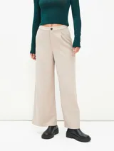 Pantalón de vestir color beige, de corte recto y tiro alto, con cierre frontal de botón y pinzas en la cintura.