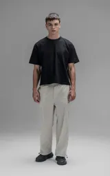 Pantalón de corte oversize confeccionado en microfibra técnica con sutil elasticidad. Presenta cintura elástica, bolsillos laterales y un bolsillo cargo con cierre de broche snap. Incluye un sistema de elásticos con tancas en los tobillos para regular la apertura y modificar la silueta.