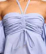 Blusa celeste de tricolina con hombros descubiertos, mangas abullonadas cortas y lazo en el cuello y parte delantera.