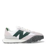 Championes urbanos New Balance modelo XC-72, con diseño combinado en blanco, gris y verde. Presentan una silueta retro-futurista con superposiciones de gamuza, paneles de cuero y una suela de goma dentada distintiva que se extiende hacia la puntera.