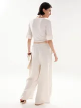 Pantalón palazzo color beige, de corte pescador y cintura alta con cordón ajustable.