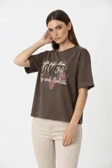 Remera de algodón color negro con cuello redondo y mangas cortas. Presenta un estampado frontal con diseño de rosas, rayos y texto, decorado con detalles de strass.