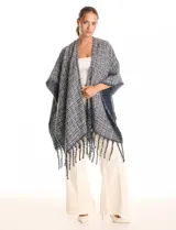 Ruana de tejido tipo tweed en tonos azul y gris con destellos de lurex. Presenta un diseño abierto con terminaciones desmechadas y flecos en todo el borde inferior.