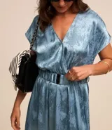 Vestido midi celeste con estampado jacquard, escote en V cruzado, manga corta y cinturón con elástico.