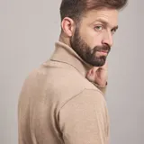 Polera color beige de tejido de punto con cuello alto.