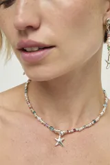 Collar de cadena con cuentas metálicas plateadas intercaladas con cristales facetados de diversos colores y dije central en forma de estrella.