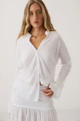 Camisa de lino color marrón, de manga larga y calce holgado, con cuello mao y escote en V.