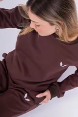 Buzo negro de algodón de corte clásico con cuello redondo y mangas largas. Tiene un pequeño logo bordado en el pecho.