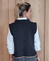 Chaleco tejido de punto con diseño abstracto en bloques de color marrón y turquesa, con cuello redondo y terminaciones acanaladas.