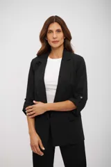 Blazer negro de corte clásico, con solapas de muesca, mangas tres cuartos con detalles de trabilla y bolsillos frontales con solapa.
