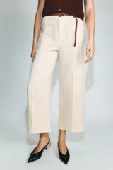 Pantalón culotte de tiro medio en color beige, con bolsillos de plastrón en el frente y costuras verticales. Incluye un cinturón trenzado fino en color marrón a contraste.