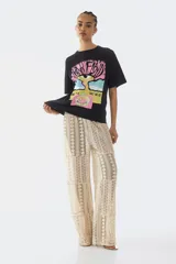 Remera negra de corte oversized con diseño estampado de Pink Floyd en el frente, cuello redondo y mangas cortas.