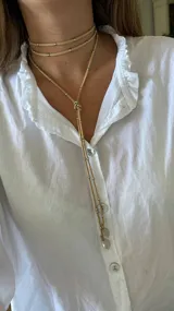 Gargantilla roja de múltiples vueltas con cuentas plateadas y dijes redondos.