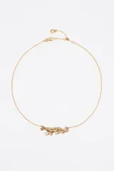 Collar de cadena dorada con un dije central con forma de pantera o leopardo en posición de marcha, con detalles de esmalte negro o piedras incrustadas simulando el pelaje moteado.