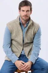 Chaleco de felpa con cierre frontal completo, cuello alto y bolsillo lateral en el pecho. Presenta una textura jaspeada en tonos beige y marrón.