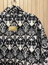 Chaqueta acolchada con estampado ikat en blanco y negro, de corte recto y cuello mao.
