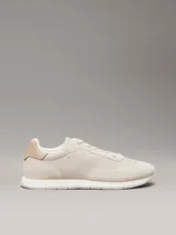 Zapatillas Calvin Klein de perfil bajo, confeccionadas en una combinación de ante, piel y lona en tonos beige. Presentan un diseño minimalista con suela de caucho y logo de la marca estampado en el lateral.