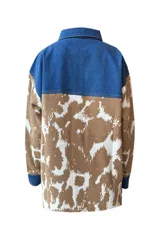Chaqueta con corte camisero, cuello y solapa de jeans color índigo. Tejido que llega bajo la cadera con bolsillos laterales. Pattern de vaca en tonos café y crudo en las mangas y parte inferior.