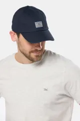 Gorro con visera de lona azul marino, con parche rectangular bordado en el frente.