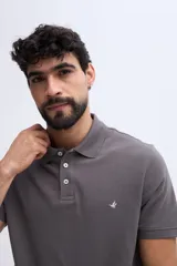 Remera polo verde militar de algodón pima, con cuello y puños acanalados, cierre frontal de tres botones y pequeño bordado de ave en el pecho.