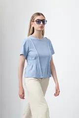 Remera de manga corta color celeste, con cuello redondo y costuras verticales decorativas en el frente que aportan estructura y entallan la silueta.