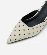 Zapato tipo mule de punta fina con estampado de lunares, diseño abierto en el talón y tacón bajo tipo kitten heel.
