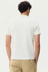 Remera polo de punto jacquard de mezcla de algodón, color blanco, de manga corta, con cuello clásico y tapeta corta de botones. Corte entallado.