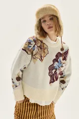 Sweater de cuello redondo con diseño de jacquard floral en cuerpo y mangas, confeccionado en tejido de punto con terminaciones acanaladas en puños y ruedo.