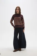 Polera de punto con diseño a rayas horizontales en contraste, cuello alto y mangas largas con puños ajustados.