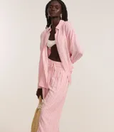 Pantalón de cambraia color rosa con rayas verticales blancas, de corte recto y cintura alta con elástico y lazo.