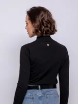 Polera color crema de tejido de punto, manga larga y cuello alto.