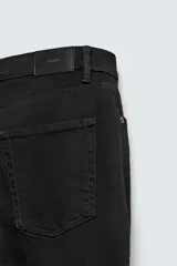 Pantalón de jean corte slim fit, color gris con efecto lavado. Presenta diseño de cinco bolsillos, cierre frontal con cremallera y botón, y tejido elástico.