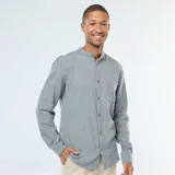 Camisa de manga larga color gris jaspeado, confeccionada en tejido de franela. Presenta cuello mao (o cuello mandarín) y cierre frontal de botones marrones. Incluye un bolsillo de parche en el pecho izquierdo.