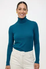 Polera de cuello alto en color azul, de manga larga con puños ajustados y tejido de punto fino.