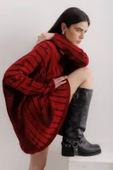 Bota bucanera de cuero color negro, con punta cuadrada, taco ancho y estribo desmontable con hebillas y tachas.