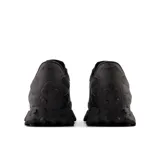 Championes New Balance modelo 327, color negro, con logo "N" de gran tamaño en los laterales, capellada de cuero y nylon, y suela exterior envolvente inspirada en los senderos.