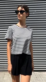 Remera gris con rayas horizontales negras, de corte crop y mangas cortas.