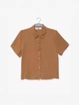 Camisa marrón de manga corta en crepé de viscosa suave, con cuello camisero y detalle floral en la botonadura central.