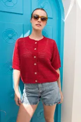 Saco tejido de punto calado con mangas al codo, cuello redondo y cierre frontal con botones de coco. Presenta un diseño versátil y ligero.