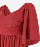 Vestido midi color bordó, con escote en V, mangas cortas evasé y falda en capas con recorte tipo María. La parte trasera tiene elástico para un mejor ajuste. Confeccionado en viscosa certificada y poliamida.